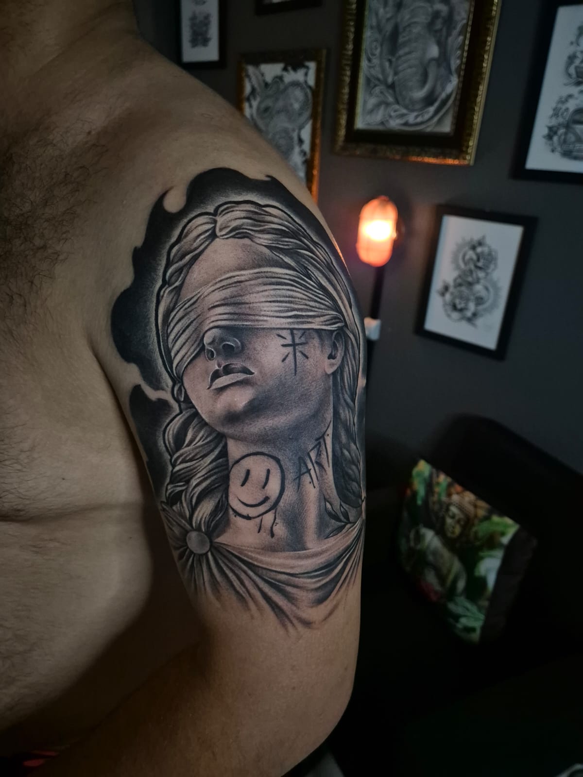 Tatuagem autoral de estátua vendada com sombreamento no braço